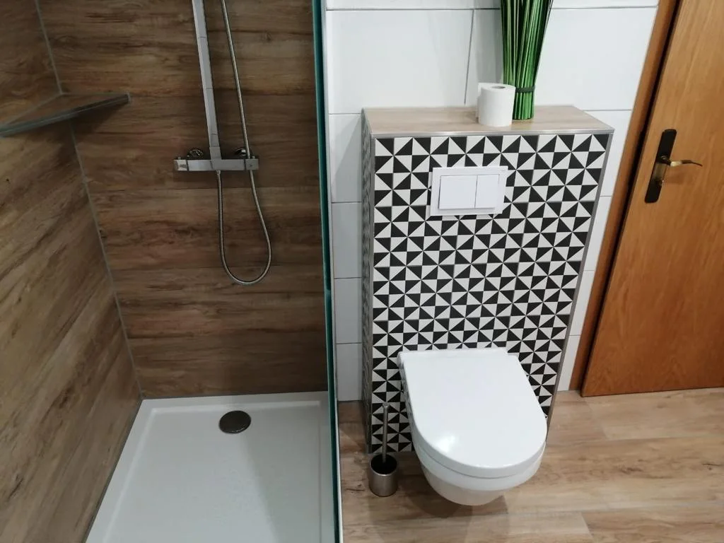 WC mit Holzoptik und geometrischen Retrofliesen